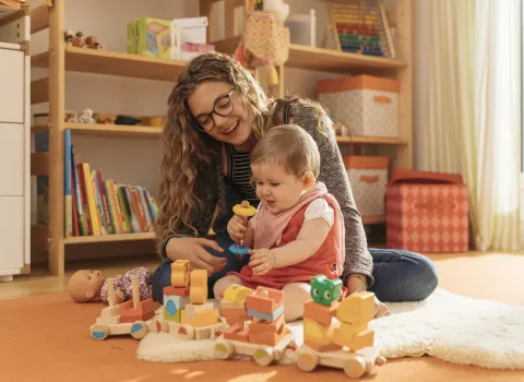 Ein Mädchen beim Spielen mit einem Baby